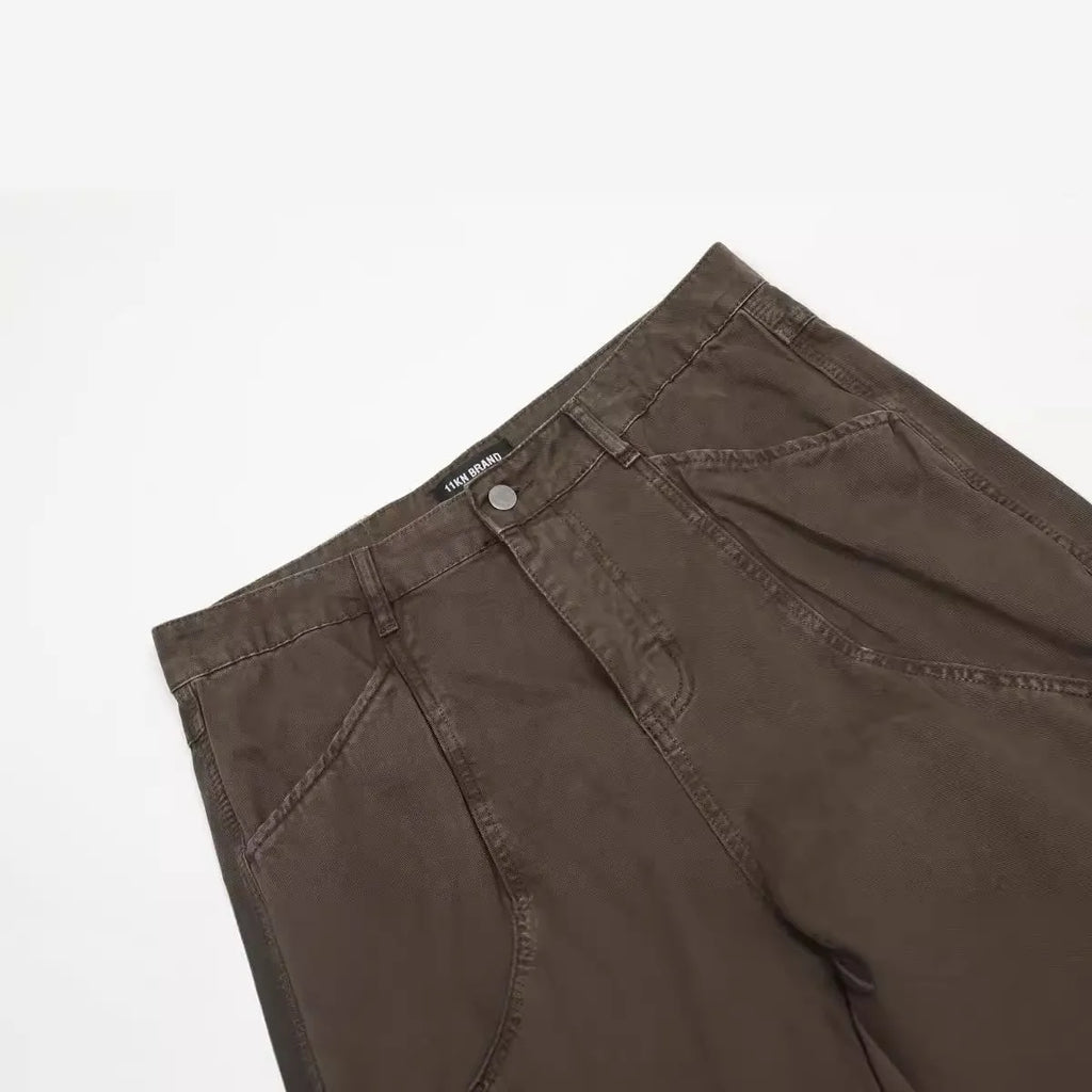 Men's brown loose fit straight leg cotton jeans with a high waist and zip fly on a hanger.