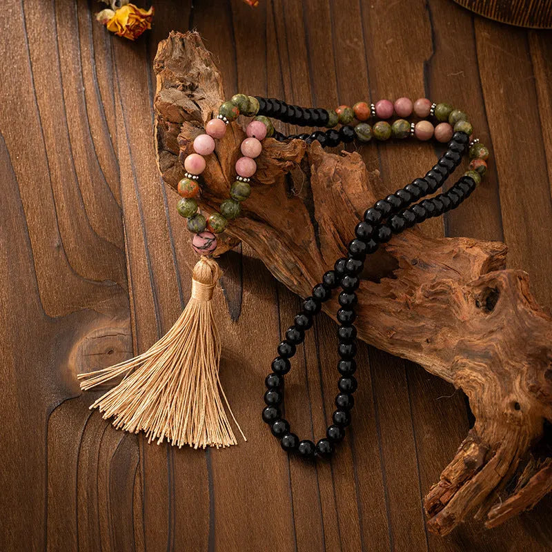 Bohemian-style long necklace chain with vintage tassel and matching bracelet on dark background