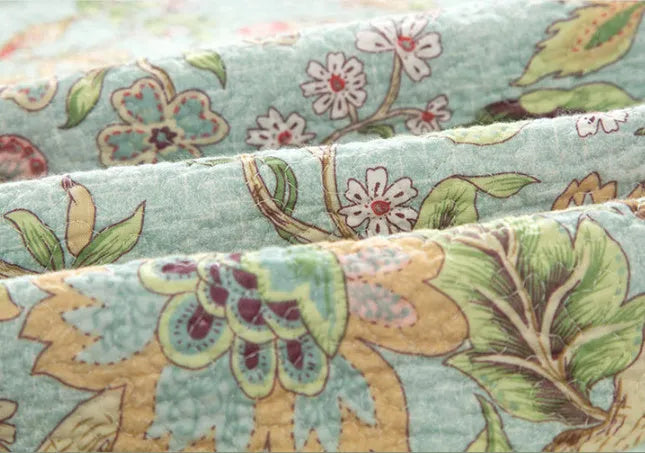 Blue American flower and bird pattern quilted cotton bedspread set on a bed