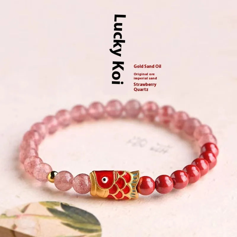 Purple cinnabar and strawberry quartz bracelet with koi and peach blossom design on a wrist.