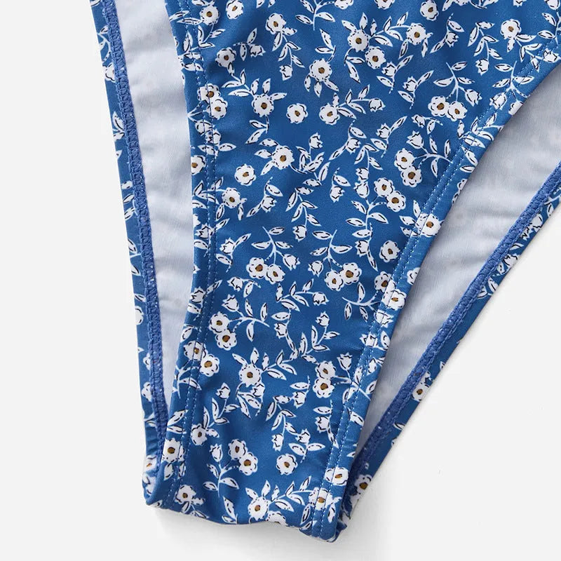 Blue women's three-piece swimsuit set with separate top and shorts on a white background.