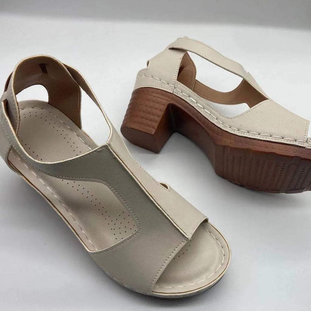 Women's beige peep toe wedge sandals with a Roman-style buckle strap on a low heel.