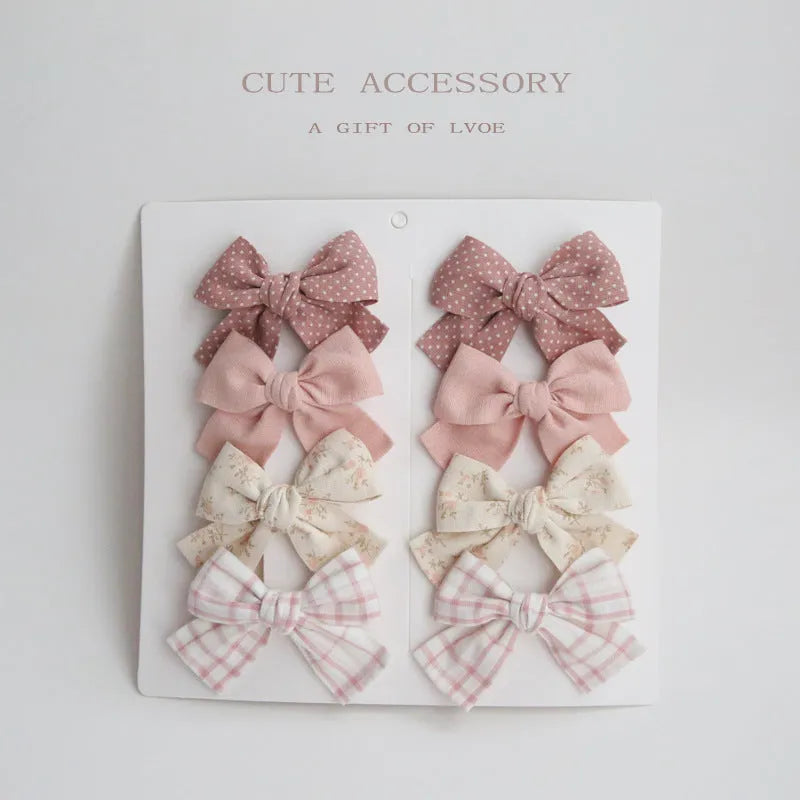 Set of eight fabric dovetail bow hairclips for children in various colours