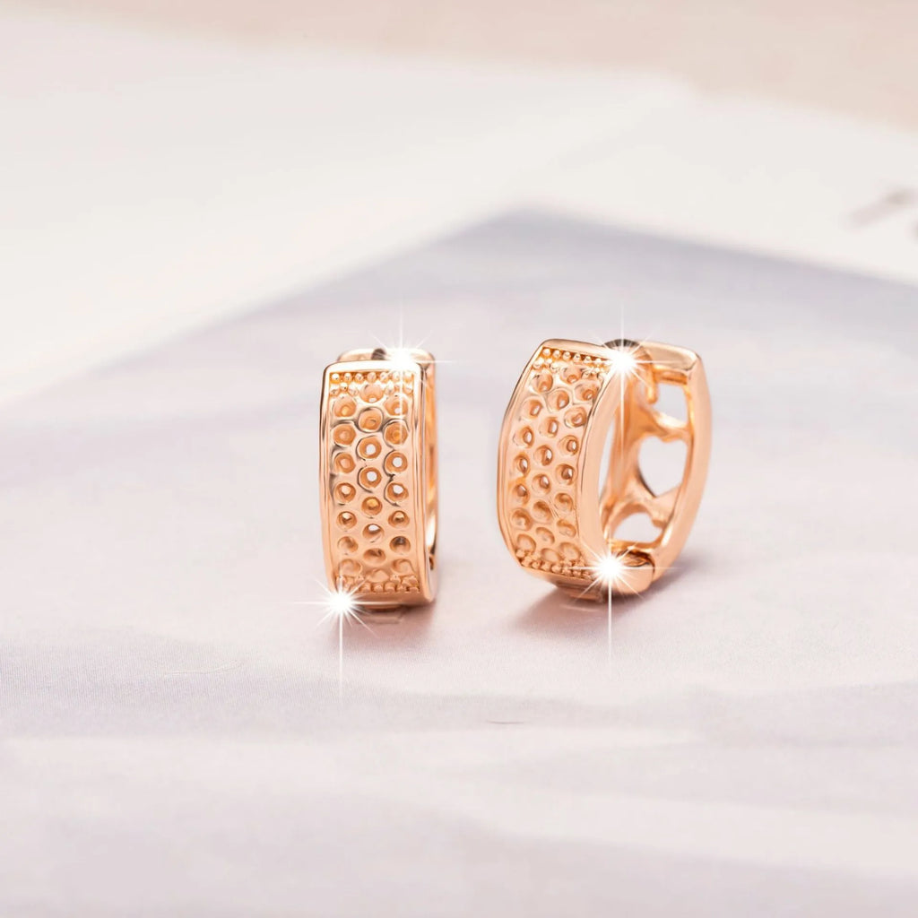 Rose gold electroplated earrings with three hollowed heart designs in circular shape