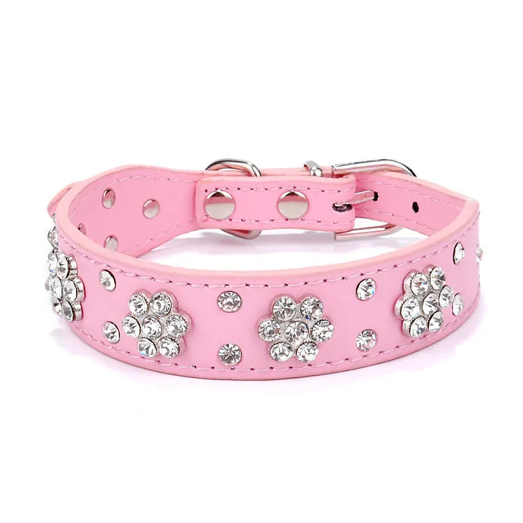 Black dog collar with studded rhinestone flower pattern and a metal D-ring on a white background