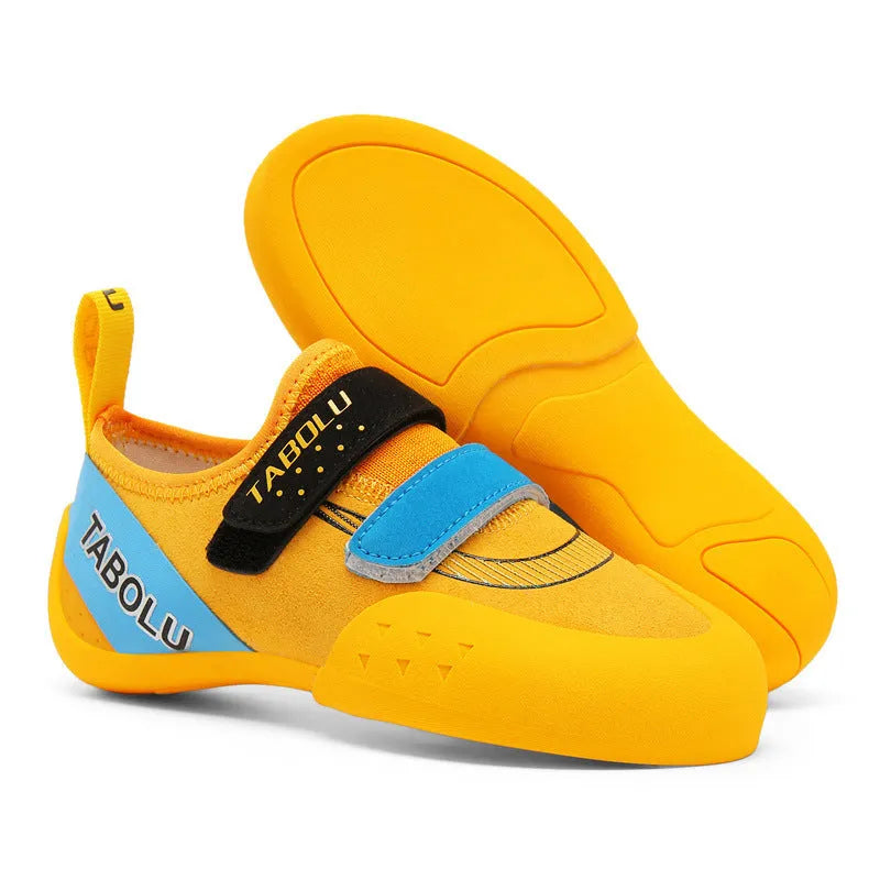 Black beginner rock climbing shoes with Velcro straps and a coloured accent on a rubber sole.