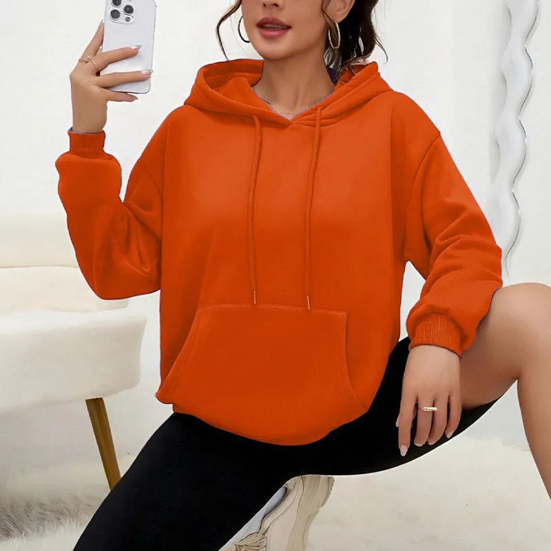 Women's loose fit grey hooded sweatshirt with drawstring and front pocket, long sleeves.