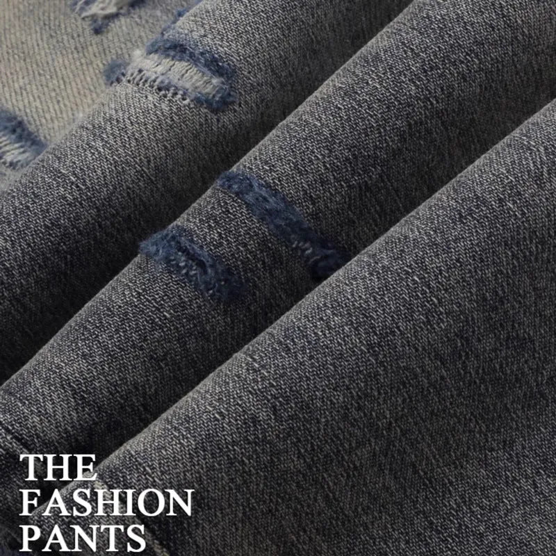 Men's vintage washed slim fit jeans with distressed holes and embroidered patch detail in old colour.