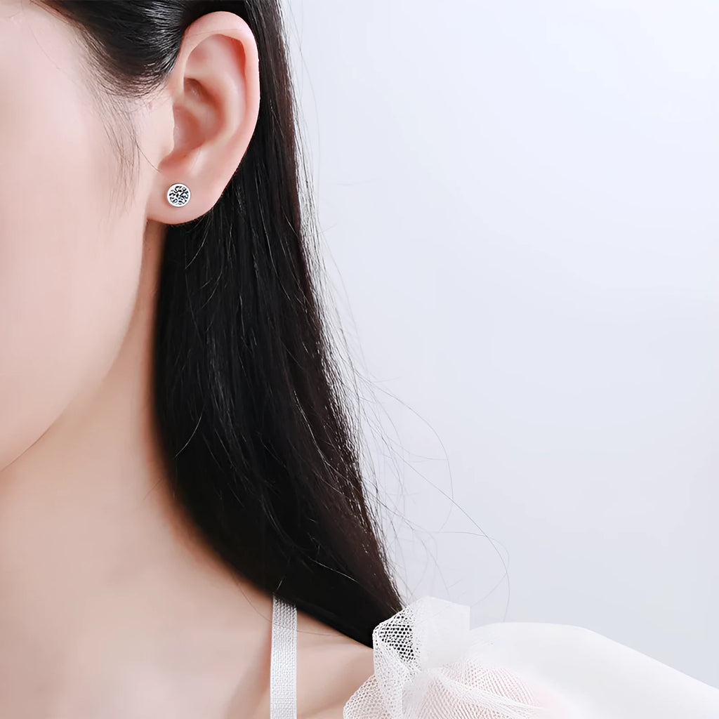 Geometric women's earrings in gold with a central moissanite or zircon stone on a silver base.