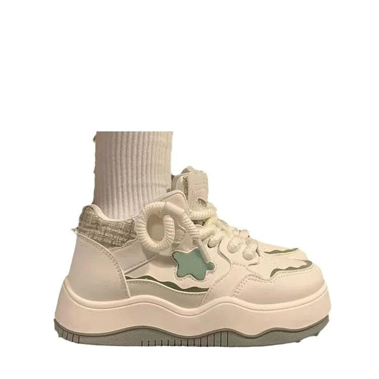 Women's green platform sneakers with round toe and lace-up design on a white background.