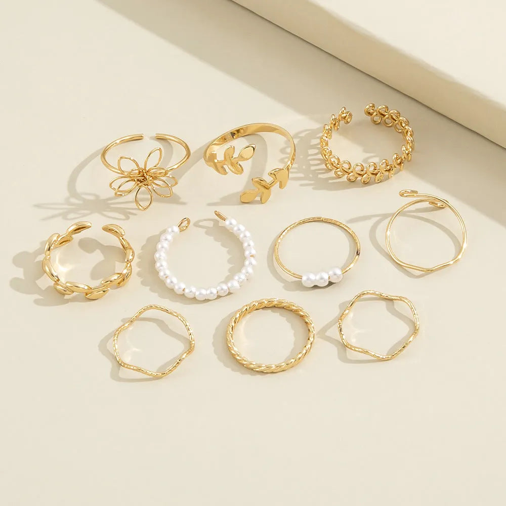 Gold tone openwork flower ring with intricate floral pattern design and glossy finish