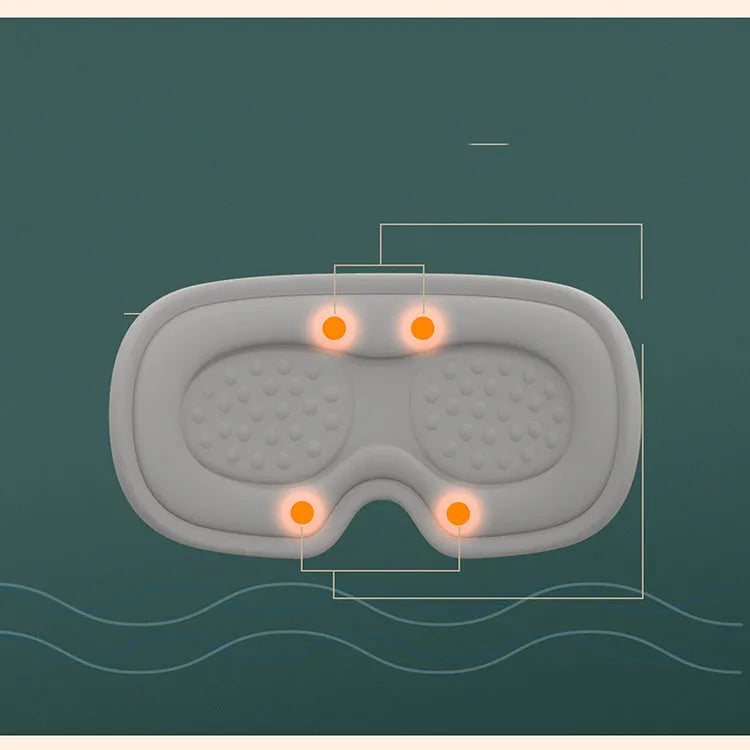Green portable eye spa massage goggles with USB cable on a table.