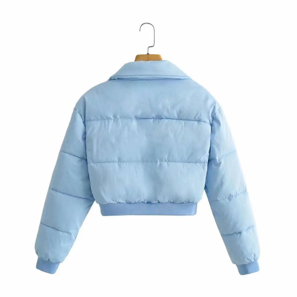 Women's loose blue polyester jacket with long sleeves on a hanger.