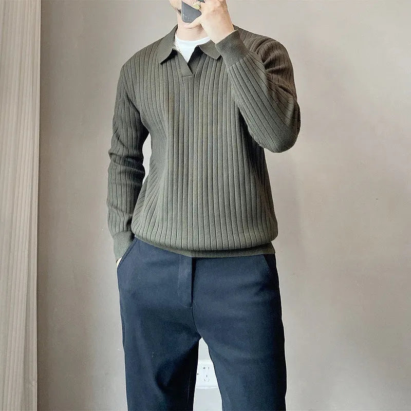 Man wearing a loose grey knitted pullover sweater with long sleeves, showing textured fabric detail.