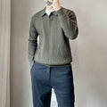 Man wearing a loose grey knitted pullover sweater with long sleeves, showing textured fabric detail.