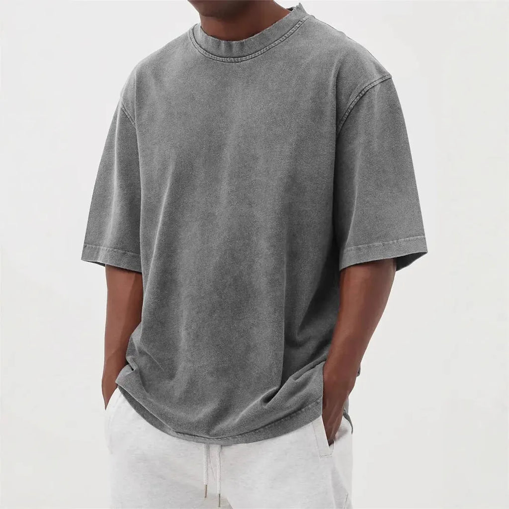Man wearing a loose-fit stone washed solid colour t-shirt in a casual setting.