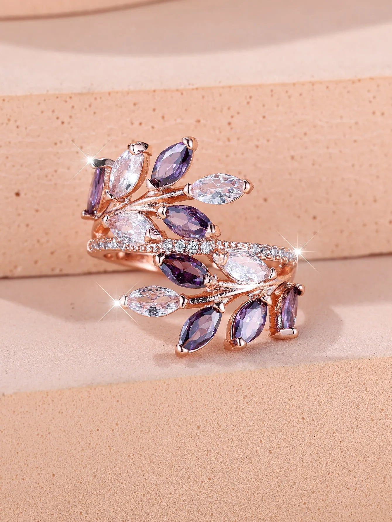 Adjustable opening copper leaf fashion ring with sparkling zirconia stones in a rose gold finish.