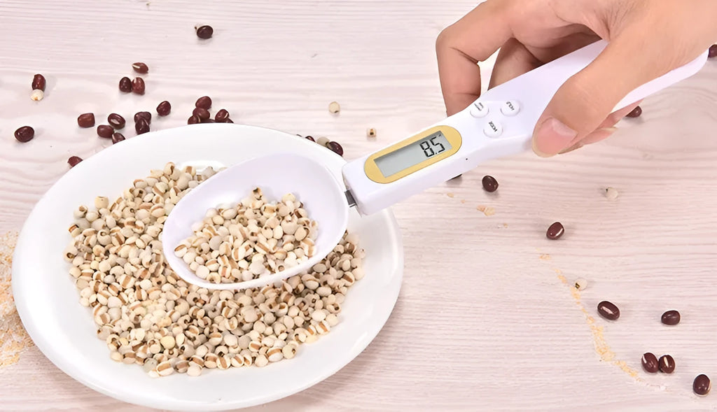 Black electronic digital measuring spoon scale on a kitchen worktop showing weight display.