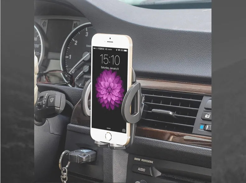 Black mobile phone holder clipped to car air conditioning vent with smartphone mounted