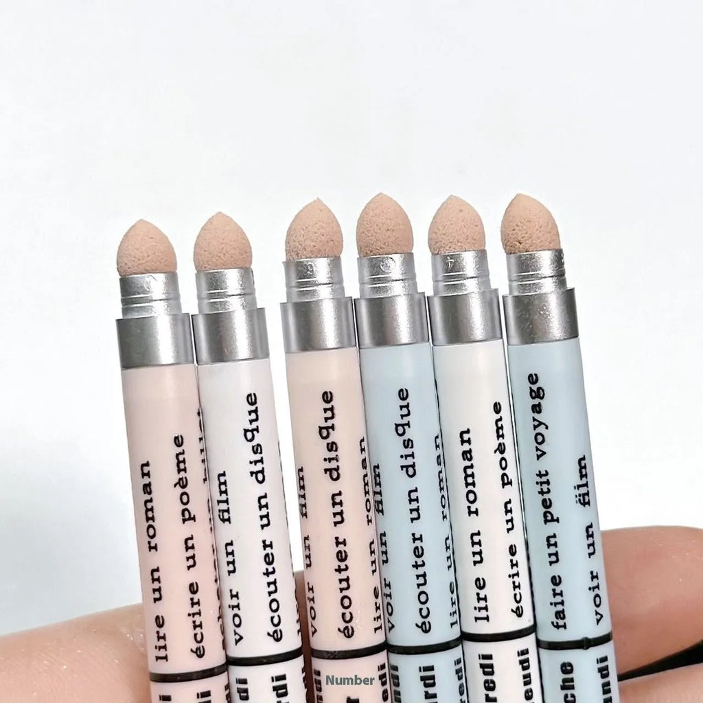 Waterproof eye shadow pen in a display showing its range of 16 colours including beige, pink, gold, and purple.