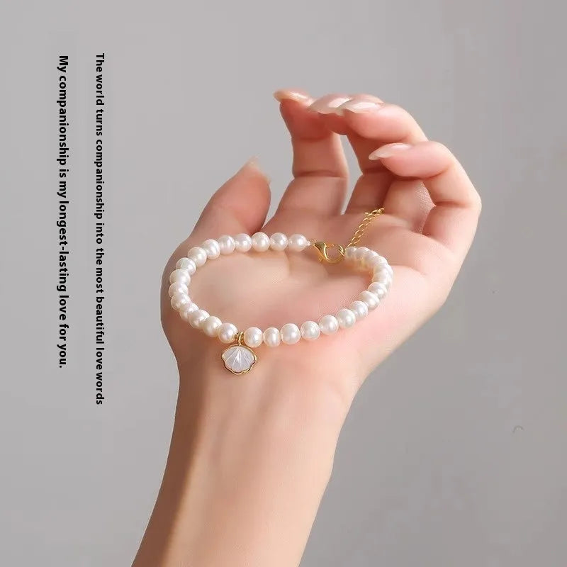 Women's freshwater pearl bracelet with fan-shaped alloy charm on a 16cm elastic string.