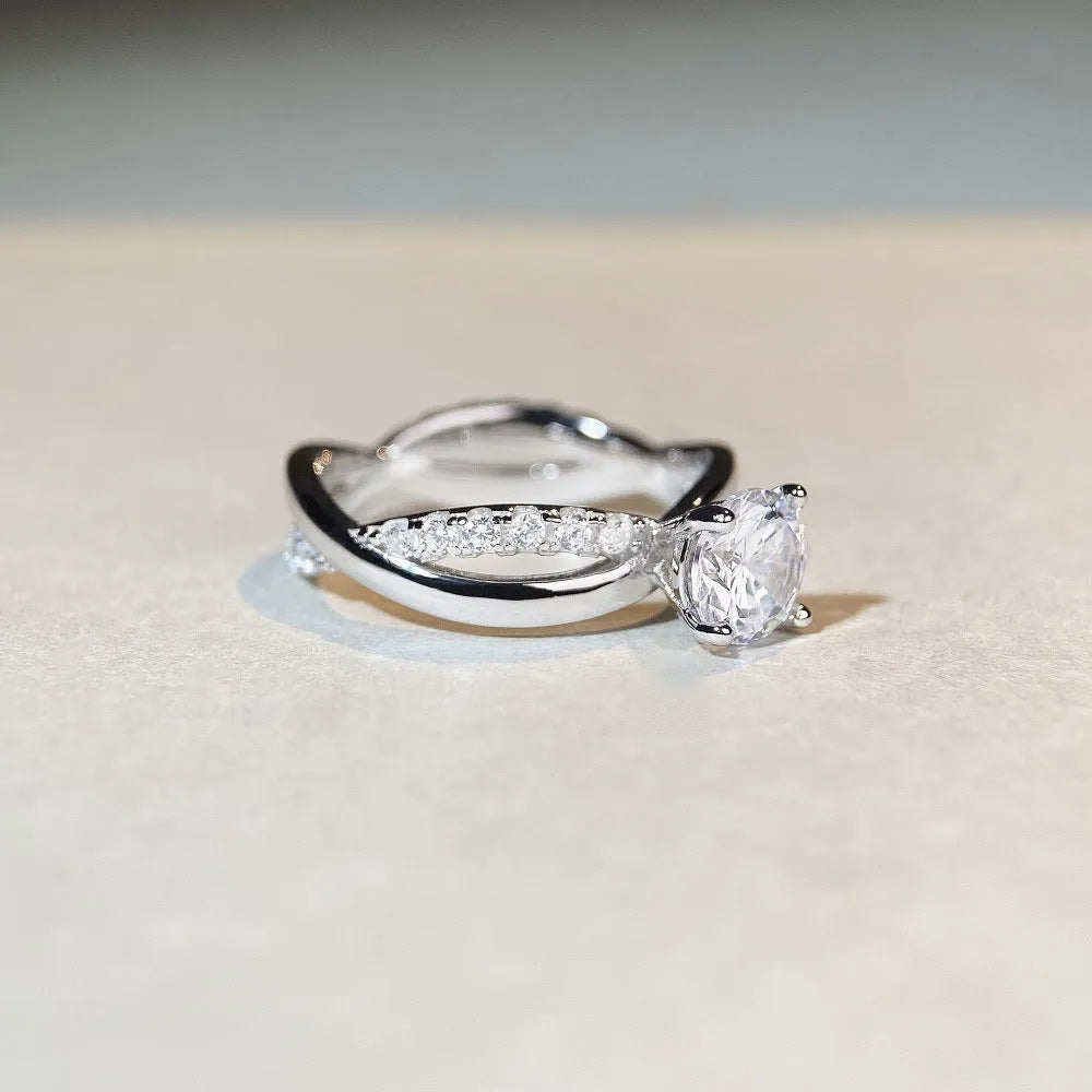 Geometric cross-design silver ring with a 1 karat moissanite stone in a four-claw setting.