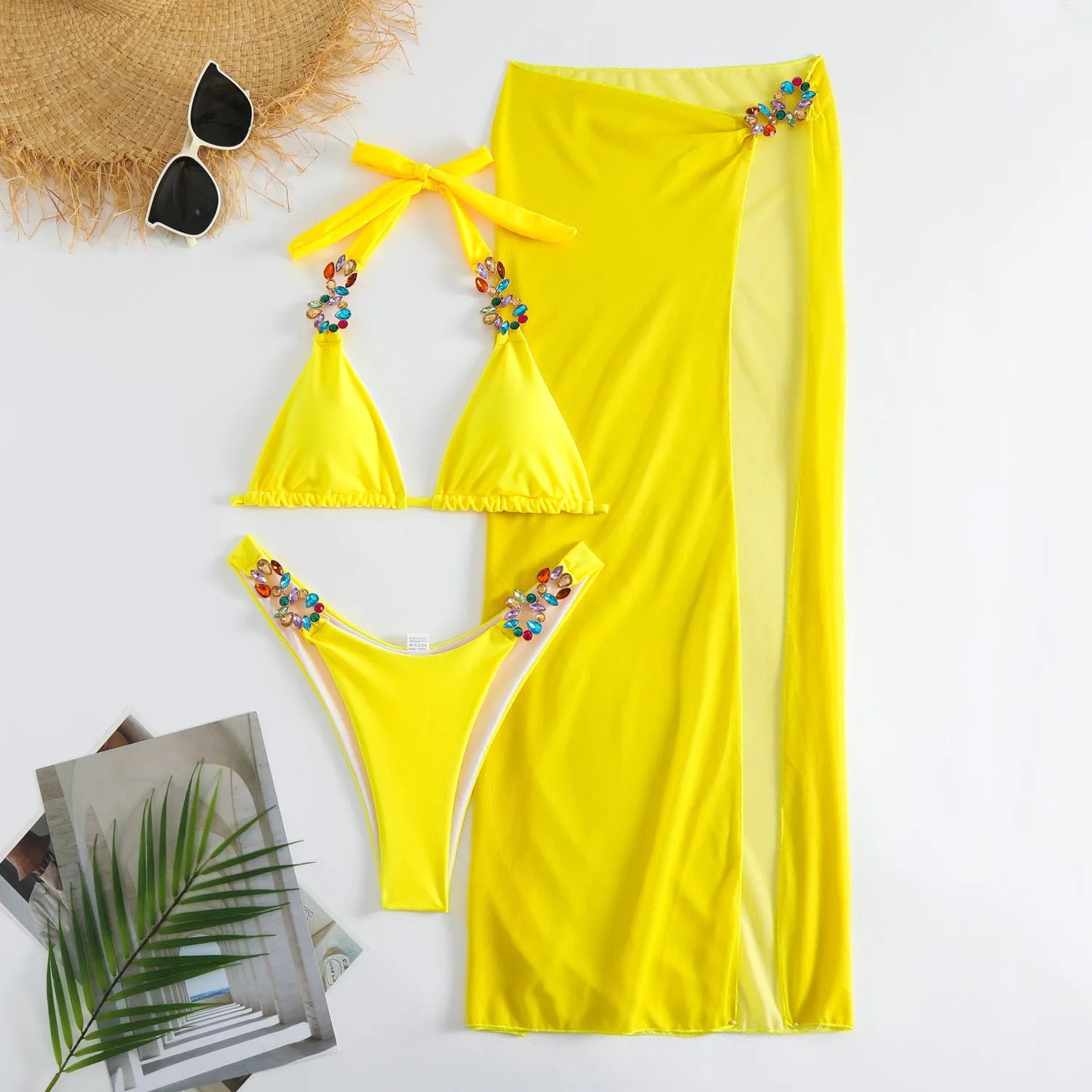 Rose red and yellow three-piece swimsuit bikini set with a mesh skirt laid flat.