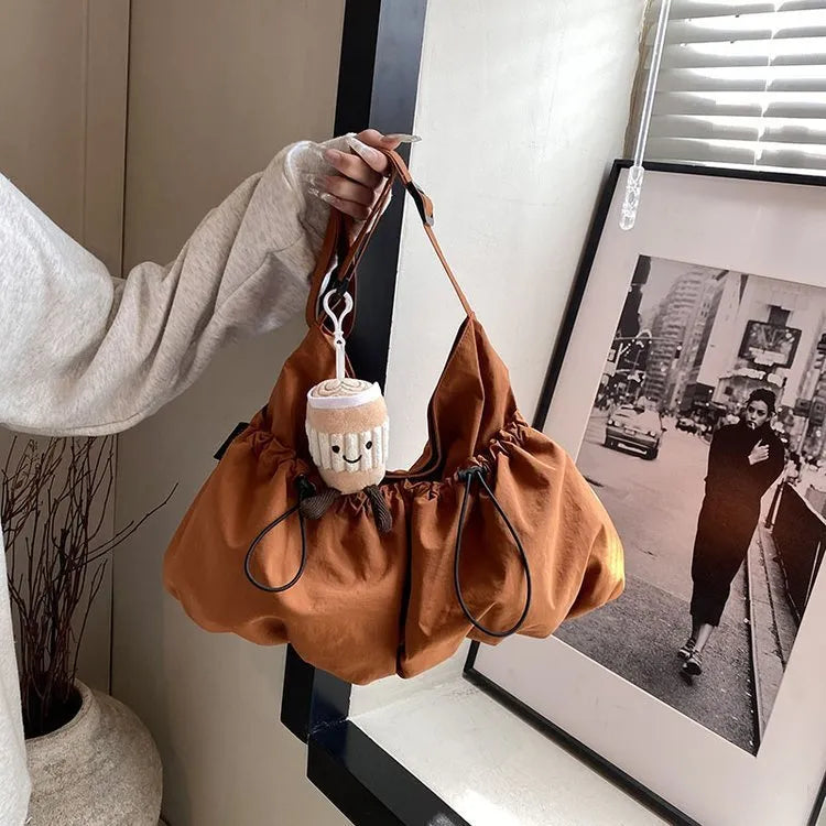 Green pleated foldable polyester crossbody bag showing split pocket and internal phone compartment.