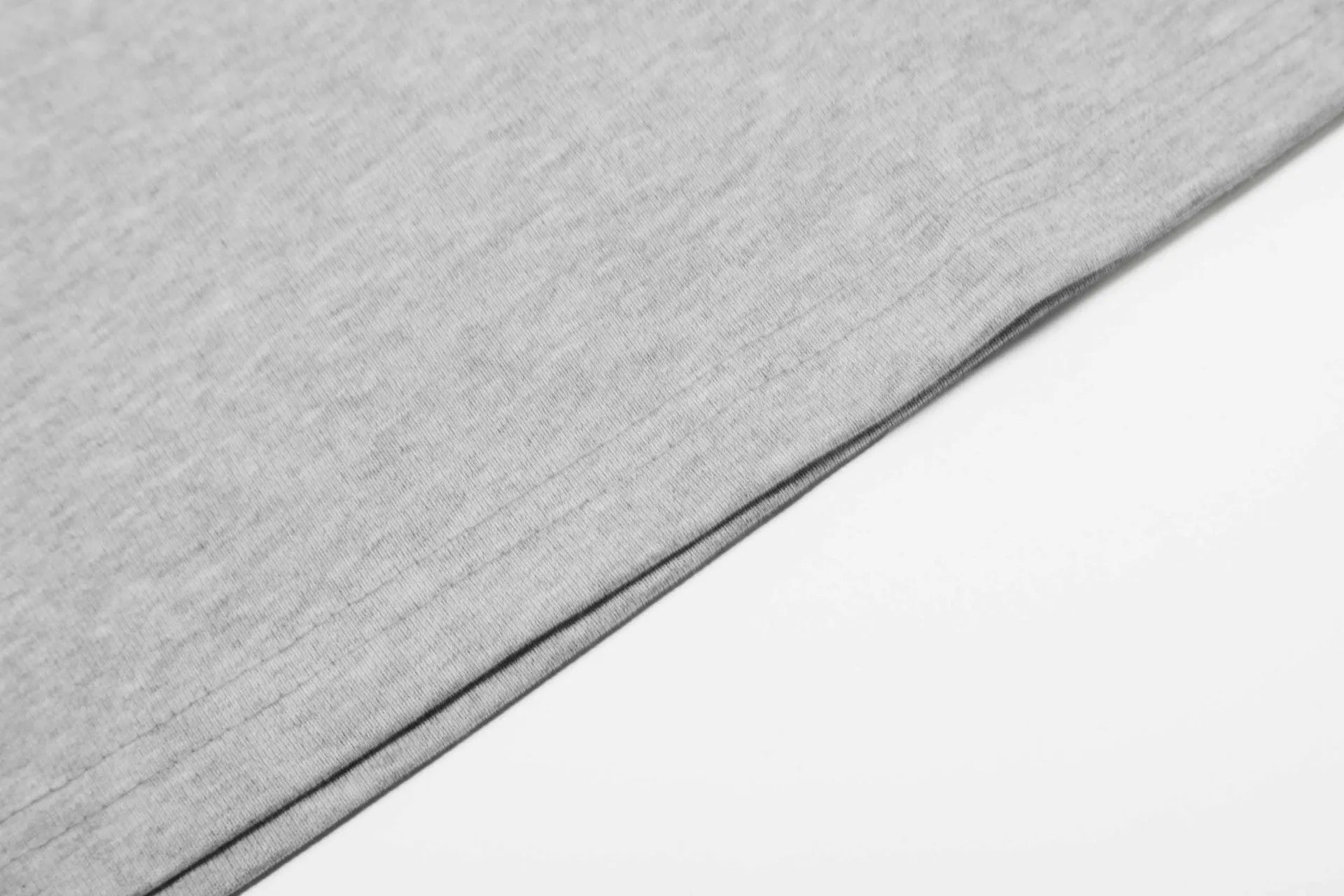 Man wearing a grey loose fit cotton long sleeve pullover with a simple retro design.