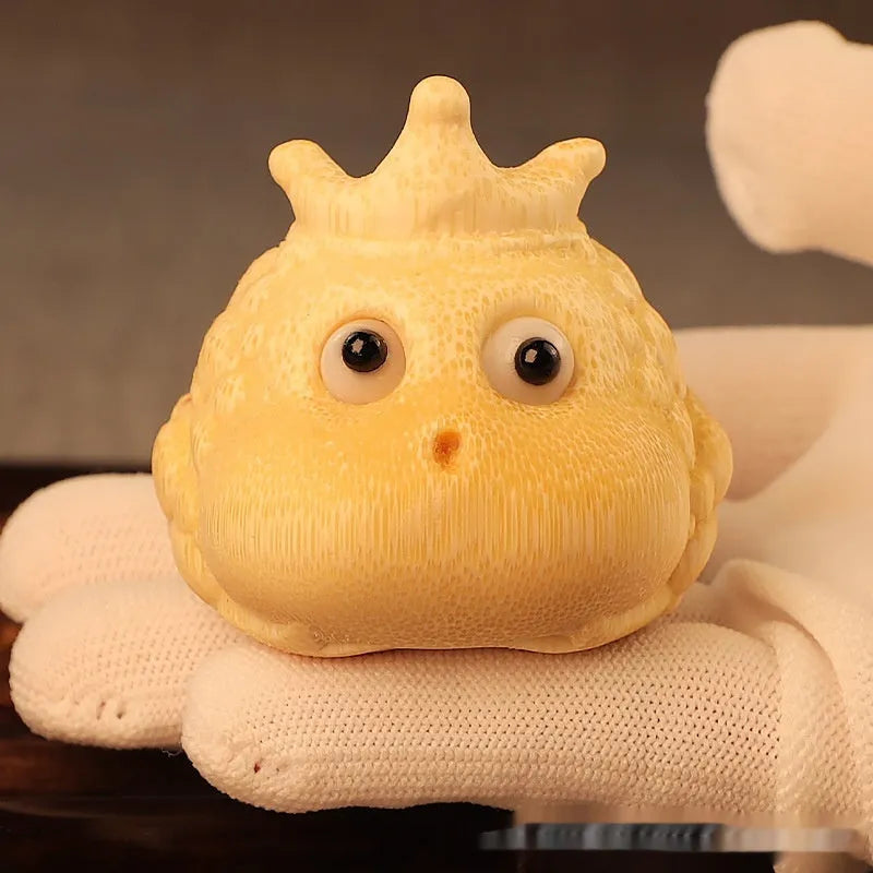 Close-up of a hand-carved bamboo Crown Princess toad ornament with live eye detailing.