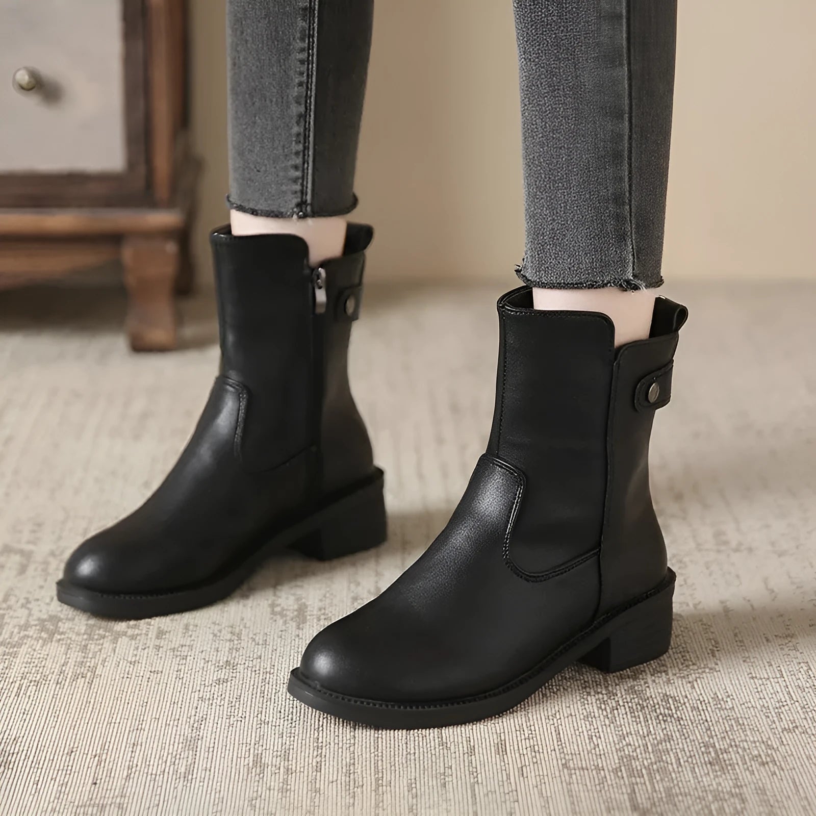 Black women's low heel ankle boots with side zip and round toe on a rubber sole
