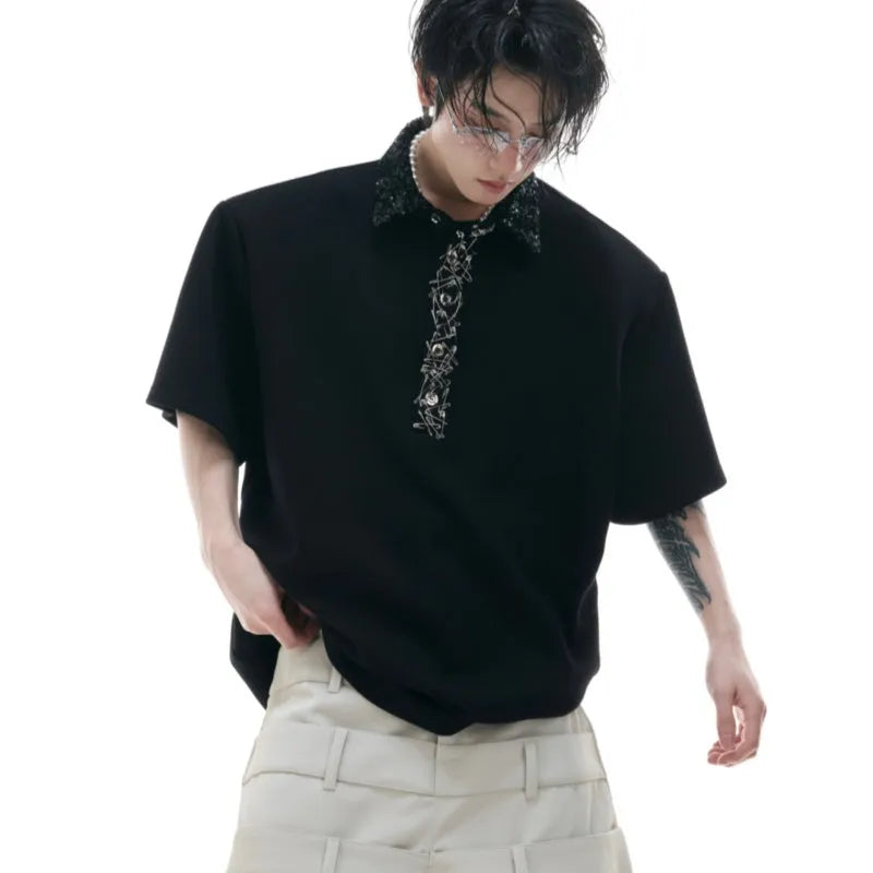 Man wearing a black loose-fit polo shirt with a square collar and short sleeves featuring sequin embroidery