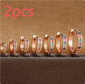 A pair of small circular zircon stud earrings with a metallic finish, shown next to a ruler indicating available sizes from 5mm to 12mm.