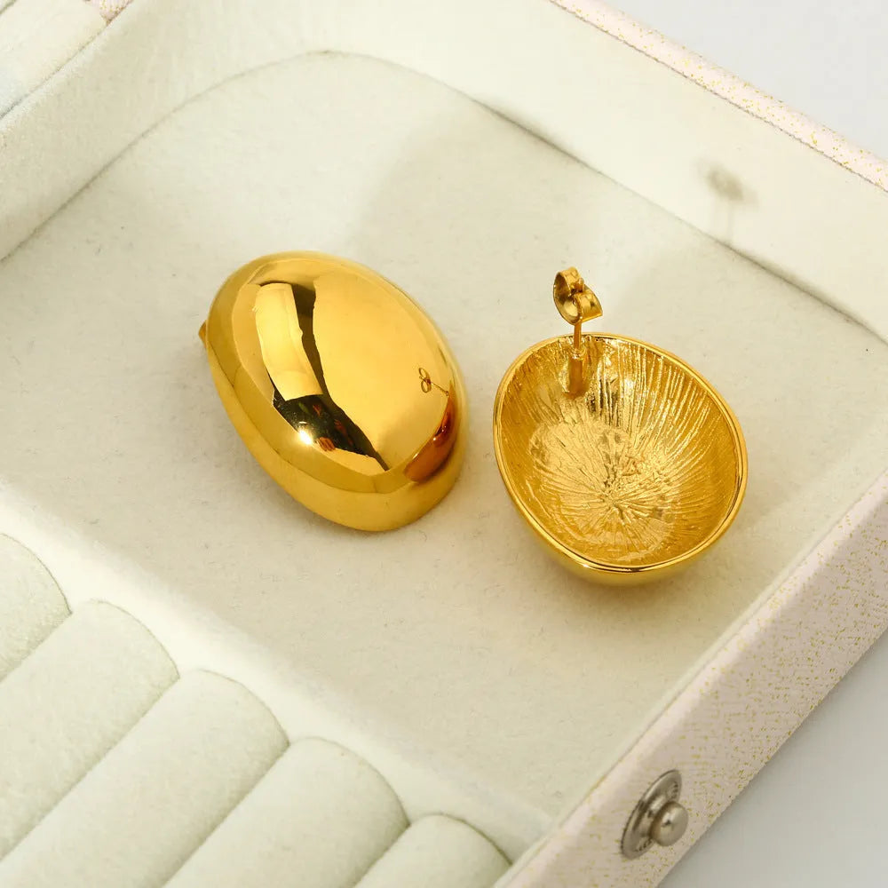 A pair of geometric stainless steel ear studs with a linear design and a glazed gold-coloured surface.