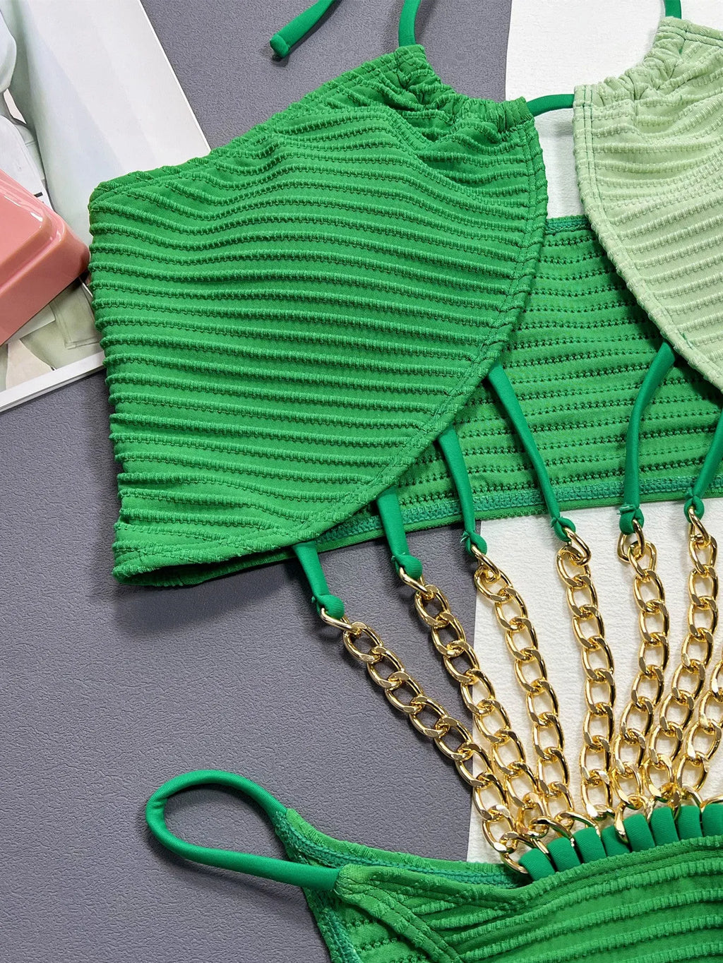Green women's one-piece swimsuit with a hollow open back design on a mannequin.