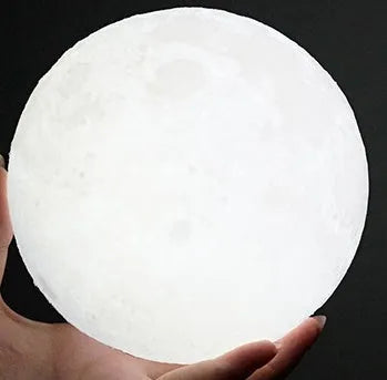 3D printed white moon lamp with textured surface on a wooden stand, showing touch ring at base.