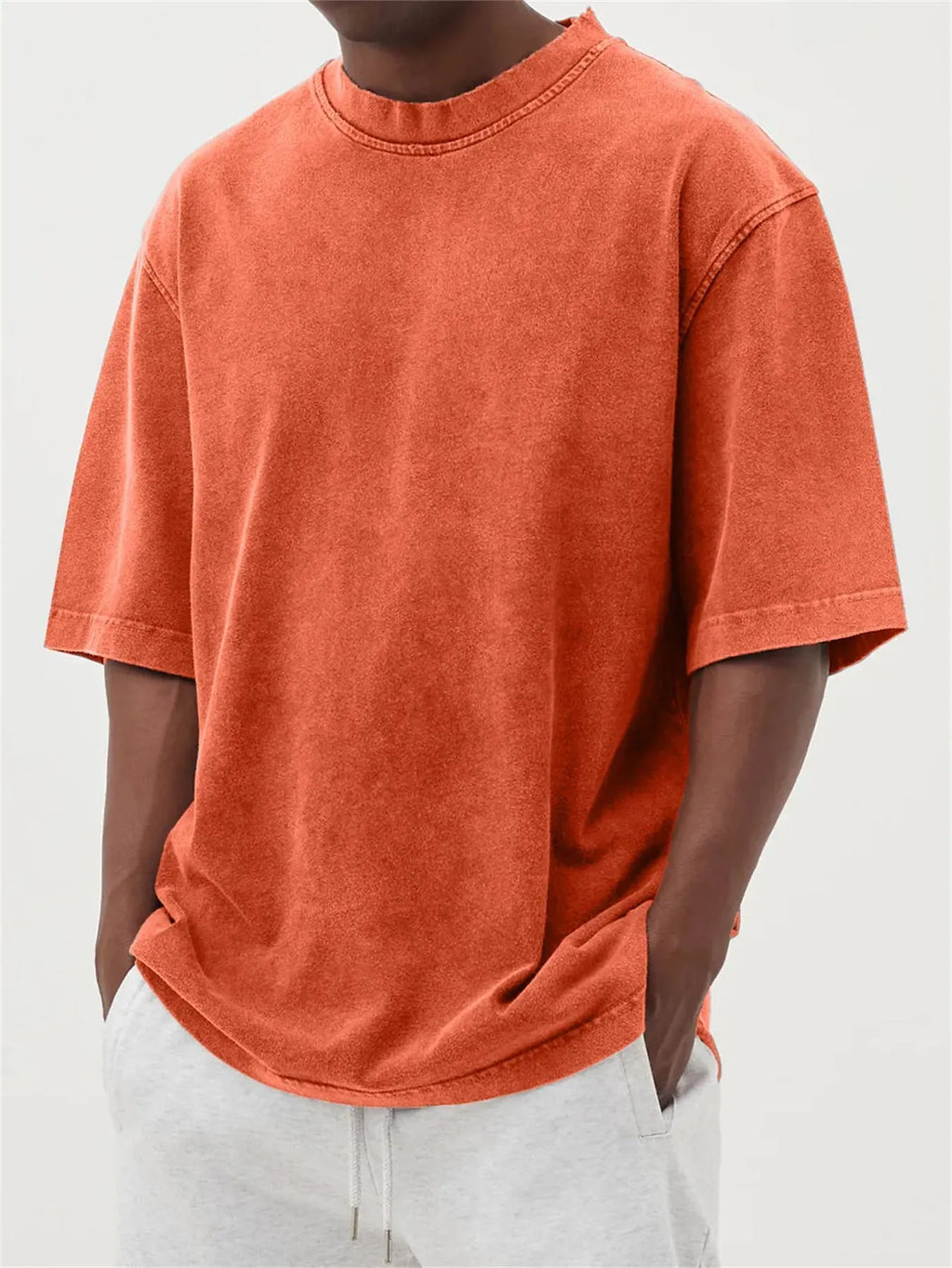 Man wearing a loose-fit stone washed solid colour t-shirt in a casual setting.