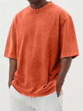 Man wearing a loose-fit stone washed solid colour t-shirt in a casual setting.
