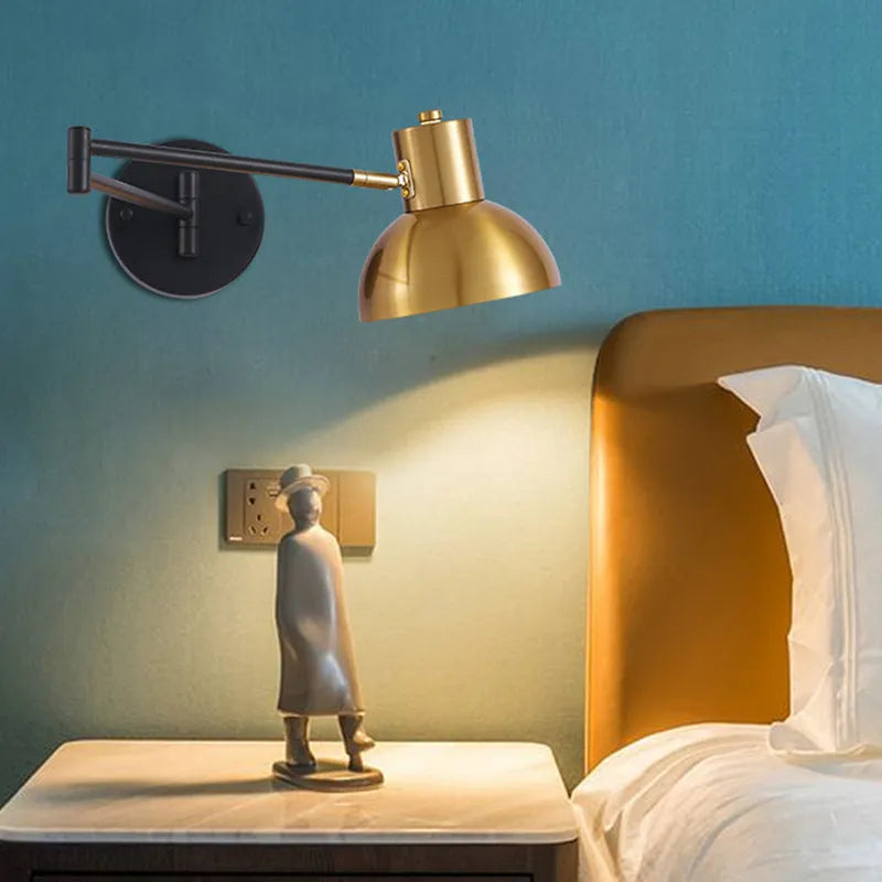 Modern minimalist double-section articulated arm wall lamp mounted on a bedroom wall.