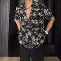 Man's loose-fit short sleeve shirt with printed floral pattern and pendant detail in black