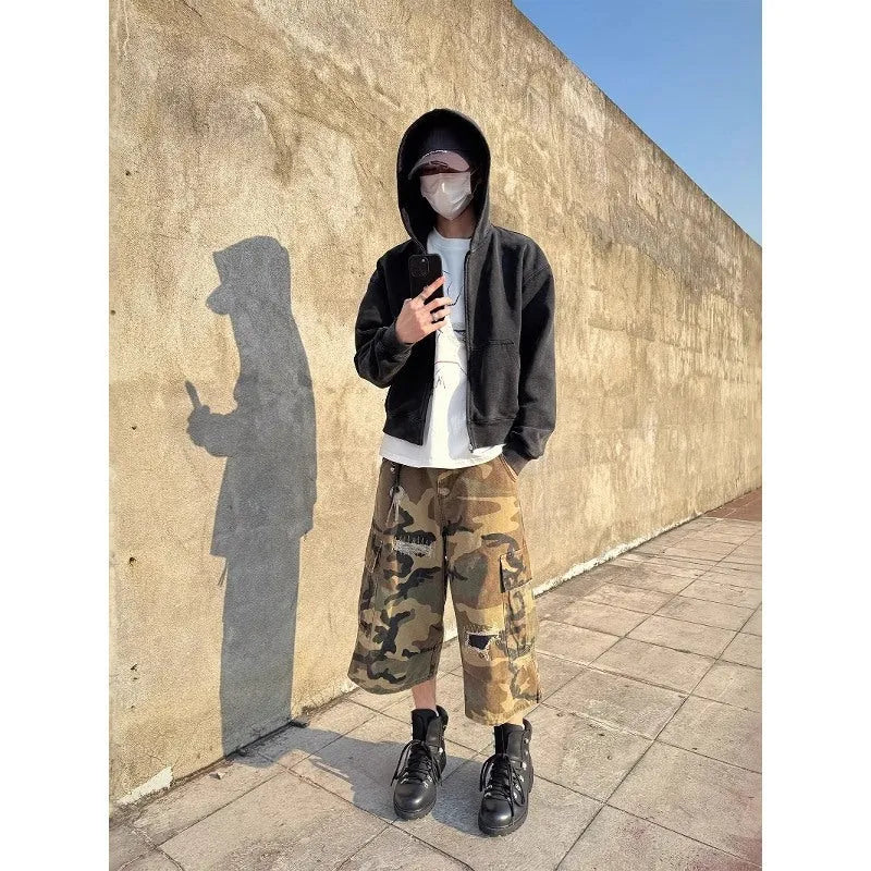 Men's camouflage-colour jeans with patch details, ripped fabric, and a cropped, loose straight-leg fit.