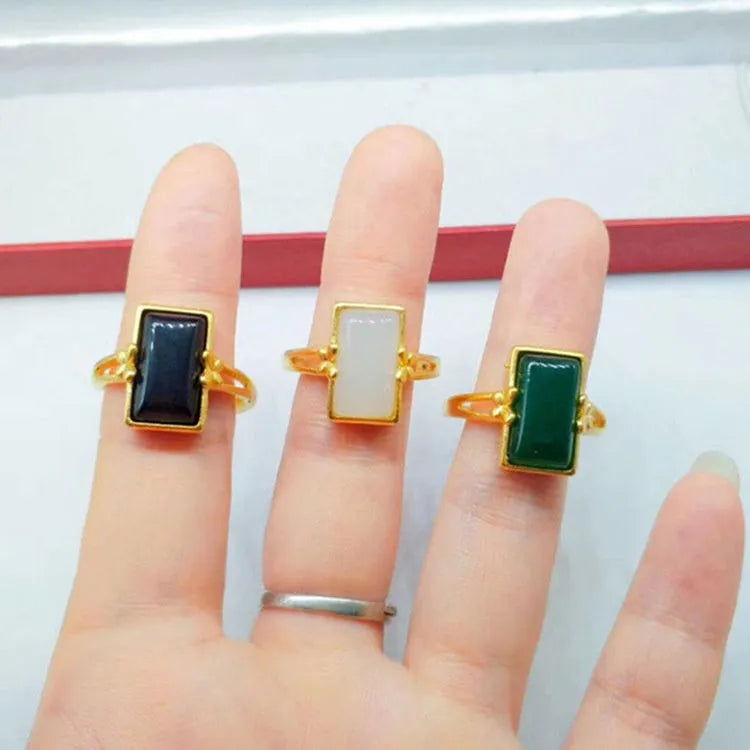 Adjustable brass gold-plated ring with an electroplated finish and a choice of black, green, or white gemstone.