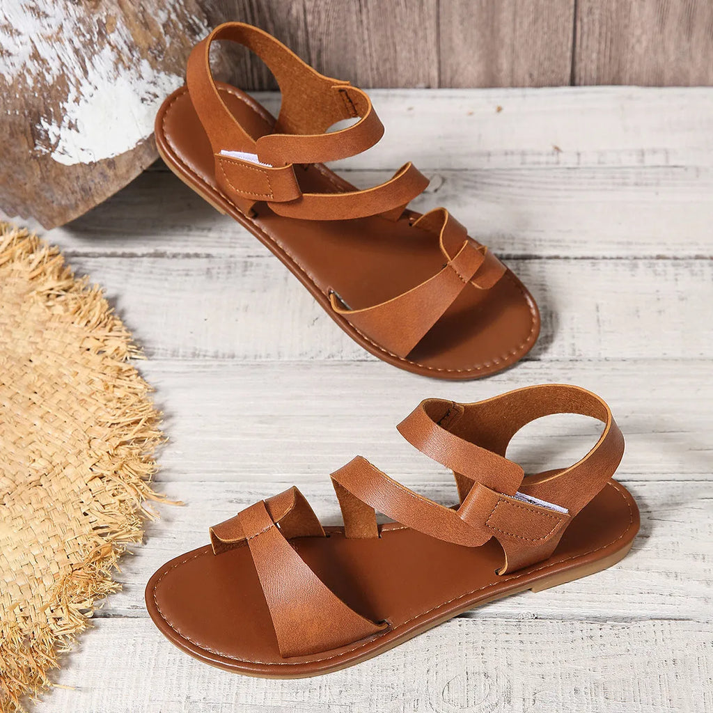 Women's flat sandals with Velcro fastening in black colour showing round toe and rubber sole
