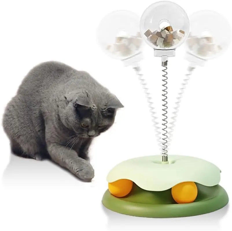 Blue and green interactive cat treat dispenser toy with track ball on flat surface
