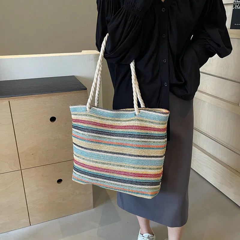 Blue straw-woven nylon shoulder bag with a single strap and large main compartment.