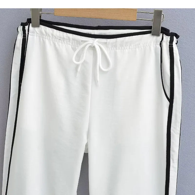 Navy blue loose straight-leg trousers with ribbon-adjustable waist and parallel bars design detail.