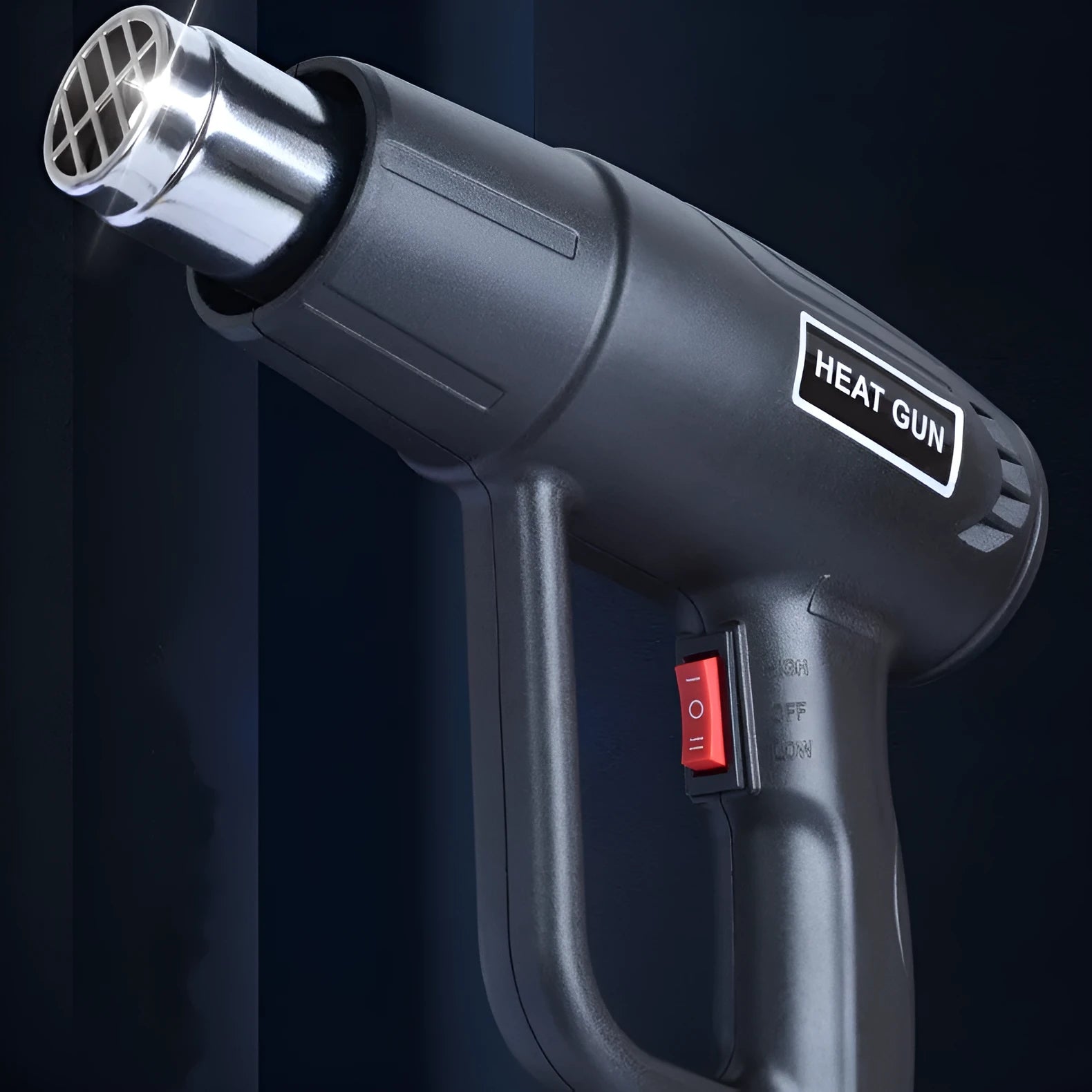 Black industrial hot air gun with a two-speed switch and grid-pattern nozzle on a workbench.