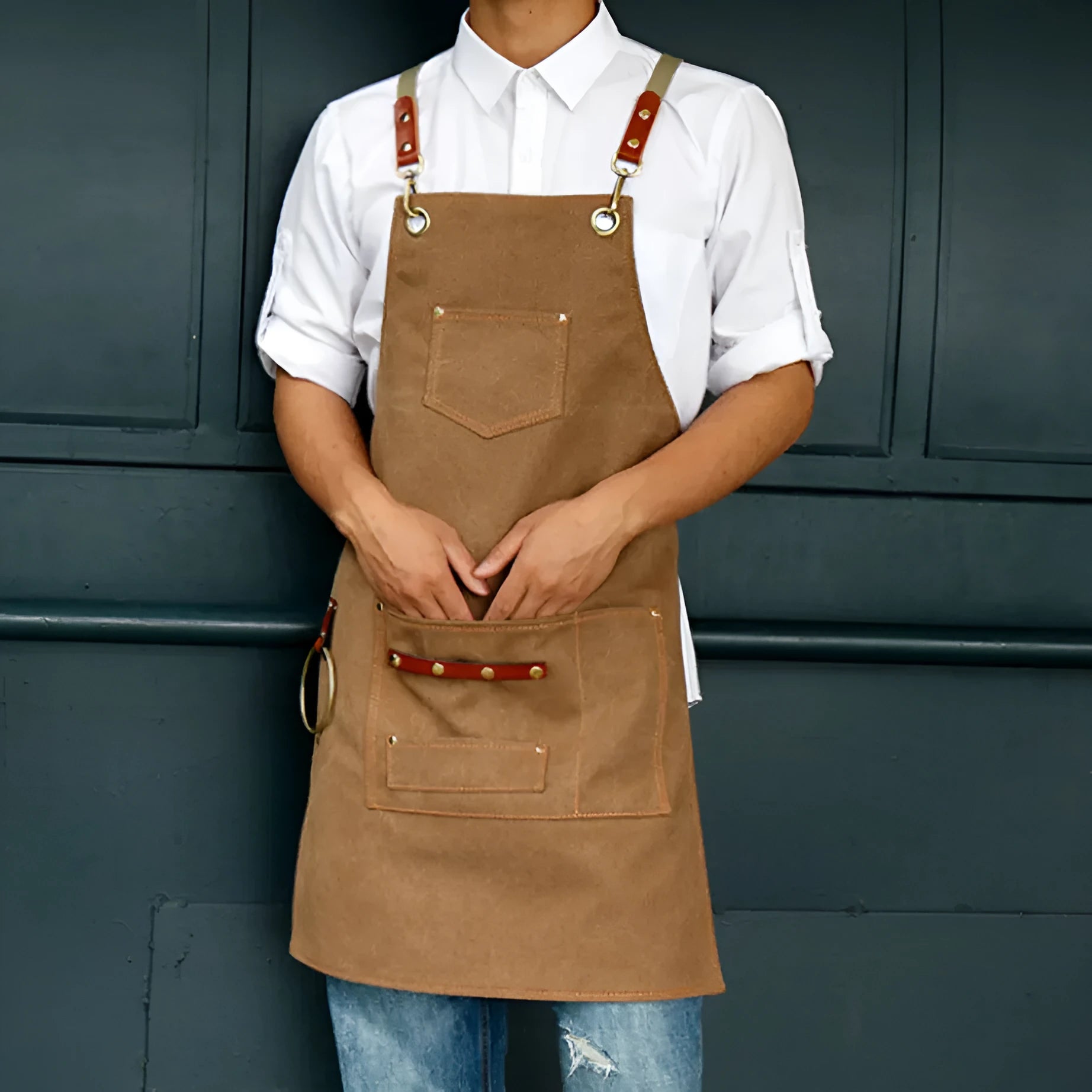 Canvas cross-back apron in camel colour on a mannequin, showing adjustable neck and waist ties