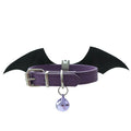 Small black leather dog collar with red devil wings and a golden bell attached.