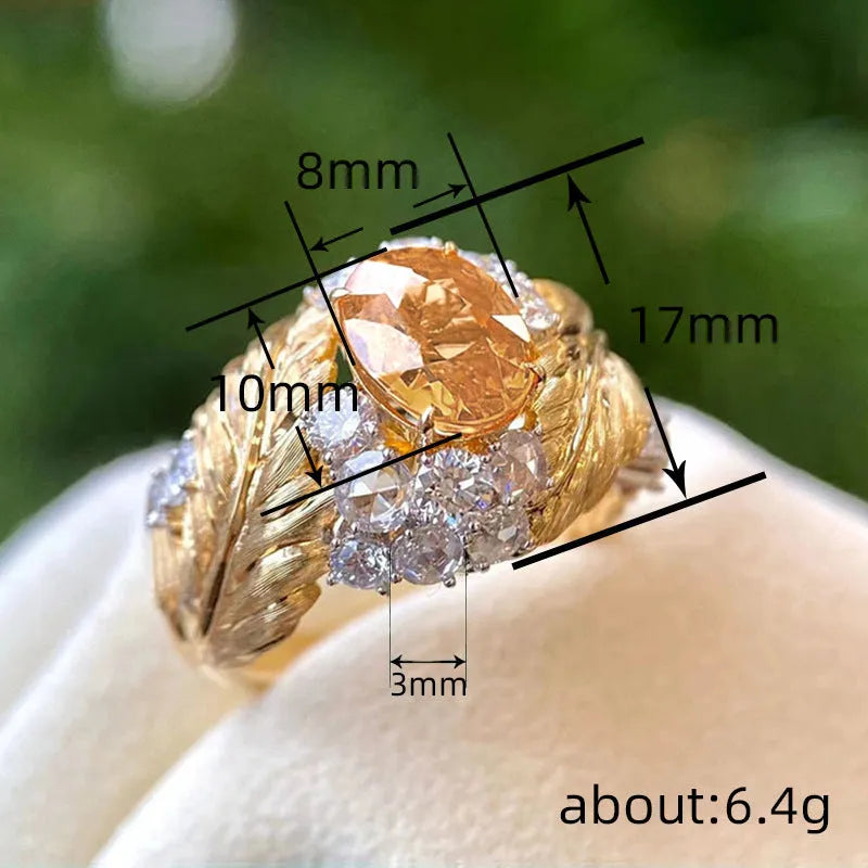 Gold-coloured copper ring with an embossed feather pattern and inlaid yellow zircon stones.